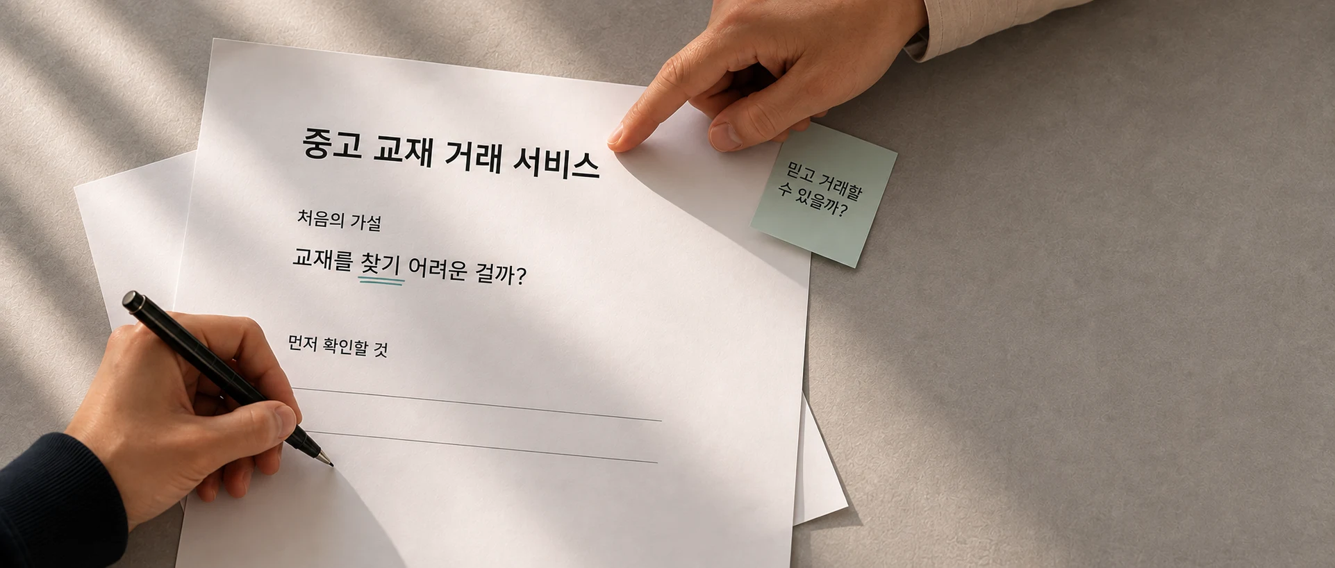 중고 교재 거래에서 무엇을 확인할지 종이 초안을 함께 살펴보는 손.